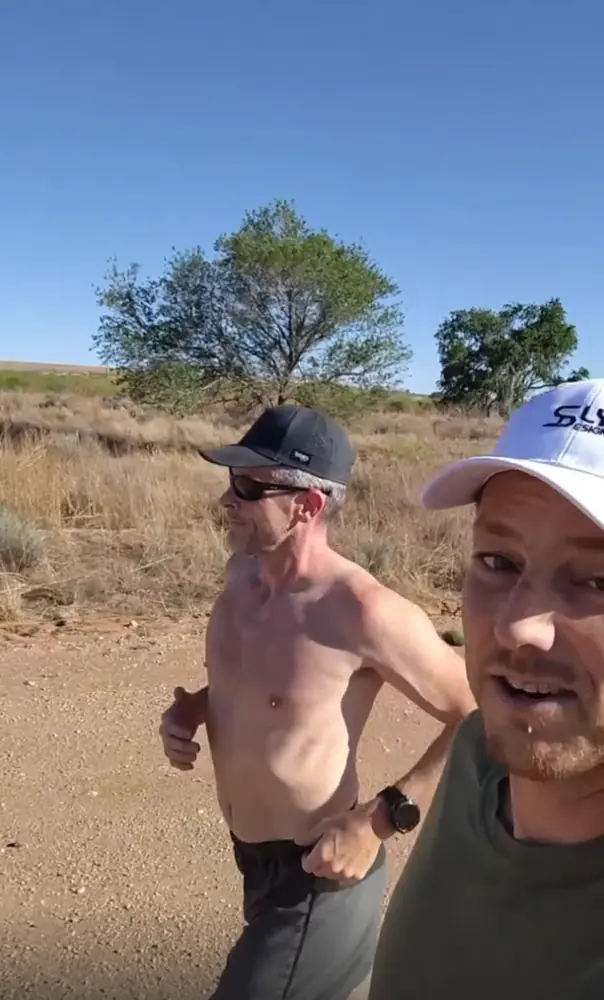 Sam and Adam running a dirt road through New Mexico grassland